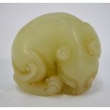 A small green jade of a recumbent, curled lion dog or other mythological animal, 4cm wide,