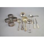 A set of four engine-turned silver napkin rings, Birmingham 1914, to/w a caddy spoon,