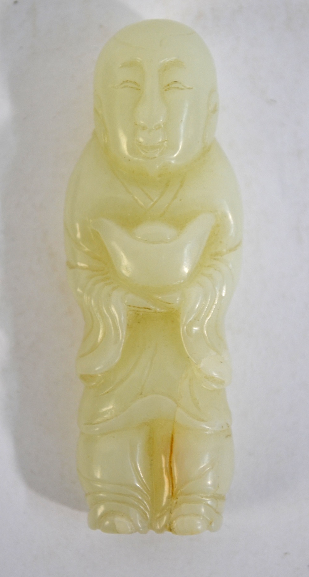 A green jade figure of a standing accolyte, holding a vessel with both hands, 6.