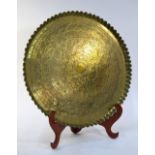 A small brass, North African or Middle Eastern tray with pie-crust rim,
