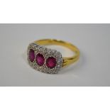 A ruby and diamond triple cluster ring, 18ct yellow and white gold setting, size M, approx 5.