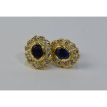 A pair of oval sapphire and diamond stud cluster earrings for pierced ears, in yellow metal setting,