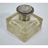 An Edwardian heavy glass inkwell with hobnail-cut base and silver collar and engraved hinged cover,