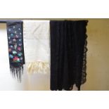 A black silk scarf embroidered with floral sprays, a cream wool evening stole,
