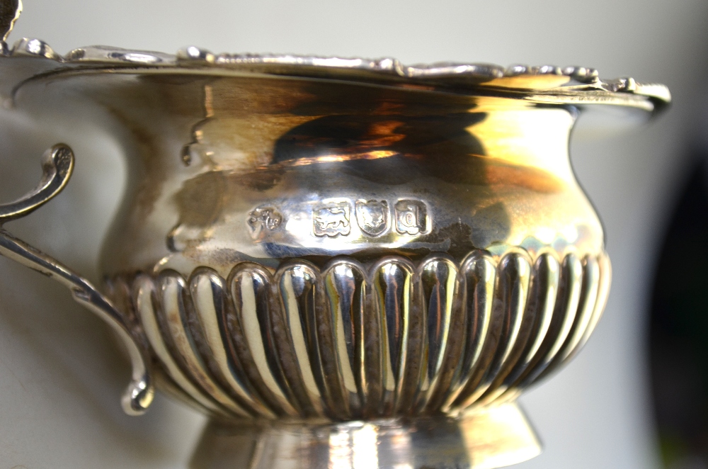 A small late Victorian silver half-reeded cream jug with decorative rim and scroll handle, - Image 5 of 6