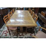 A substantial oak and burr oak refectory dining table, raised on trestle ends to sledge feet,