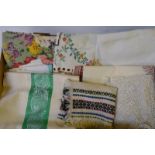 Two boxes containing a quantity of table linen to include embroidered tablecloths,