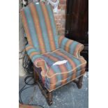An 18th century style upholstered high back armchair over a bobbin turned under frame,