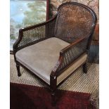 A moulded walnut framed bergere library armchair with overstuffed seat