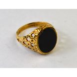 A 9ct oval onyx set gentleman's signet ring with pierced shoulders,