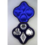 An unusual Edwardian cased set of four novelty silver pin-dishes, shaped as card-suits,