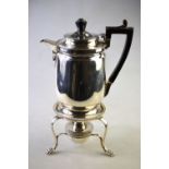 An Edwardian heavy quality silver hot water jug on stemmed foot with ebonised handle,