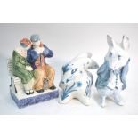 Thee Rye Pottery figures - Old couple seated on a bench raised on a rectangular pedestal,