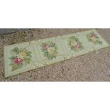 An Aubusson style wool runner with pale green ground with four floral design compartments,