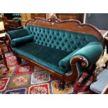 A Regency mahogany framed button backed sofa with scroll over arms raised on turned legs,
