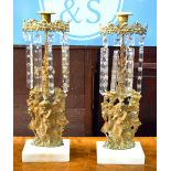 A companion pair of cast gilt lustres hung with crystal drops, on white marble bases,