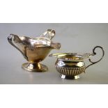 A small late Victorian silver half-reeded cream jug with decorative rim and scroll handle,