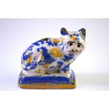 A rare English 17th century tin-glazed earthenware quill holder in the form of a cat seated on a