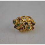 A 9ct yellow gold pierced dome style ring set with small rubies, sapphires and emeralds, size L 1/2,