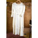 A 1920s cream muslin dress with applied trailing braid and pom-poms,