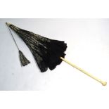A 19th century French ivory silk and black lace parasol on finely carved ivory folding handle,