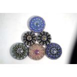 Six Perthshire paperweights, all of cartwheel design with millefiori canes and paper labels,
