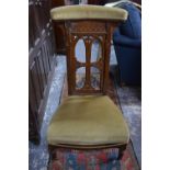 A Victorian oak Gothic styled pre-dieu chair having an overstuffed top rail and confirming seat