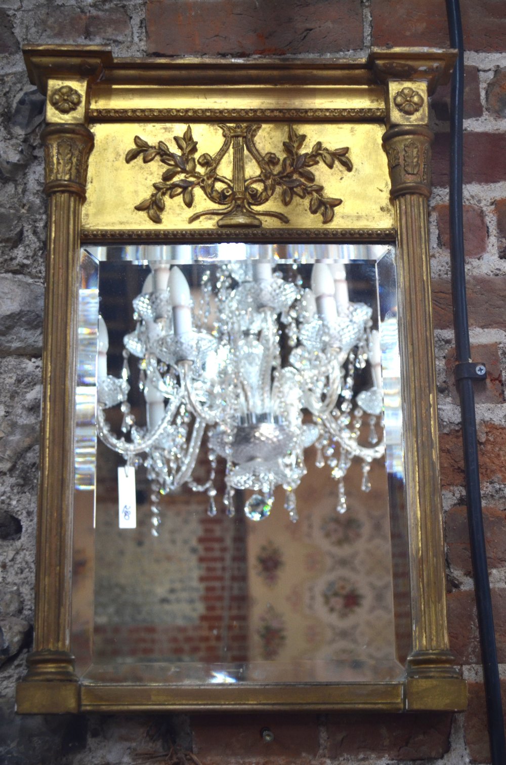 A small Regency gilt-framed pier glass with cornice tip and reeded pilasters,