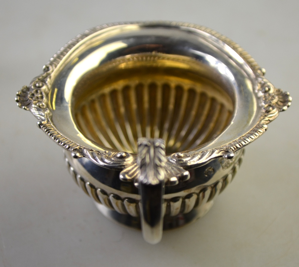 A small late Victorian silver half-reeded cream jug with decorative rim and scroll handle, - Image 4 of 6
