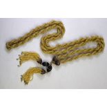 A long soutoir rope of seed pearls with ruby set terminals and detachable tassels having ruby set