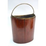 A George III mahogany bucket of ovoid form, having a folding brass handle and with brass liner,