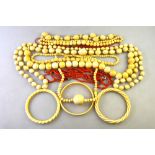 A collection of five rows of antique ivory beads to/w two carved ivory bangles in twisted style,