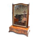 A 19th century mahogany toilet mirror on serpentine three-drawer base and ogee moulded bracket feet,