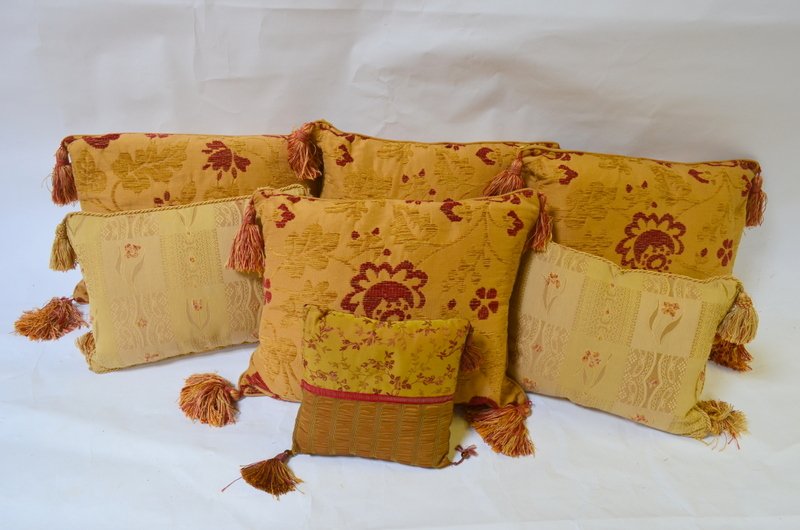 Four old gold/red floral tasseled cushions,