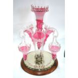 A 19th century cranberry glass epergne, one large trumpet vase surrounded by three smaller trumpets,