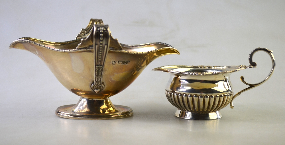 A small late Victorian silver half-reeded cream jug with decorative rim and scroll handle, - Image 2 of 6