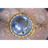 A Victorian style convex mirror surrounded by a spread wing eagle,