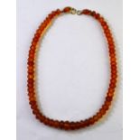 A single row of graduated facetted amber beads on yellow metal snap, approx 15g,