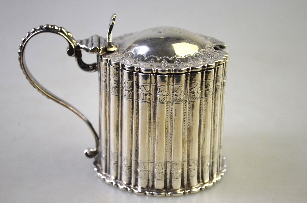 A Victorian silver mustard of reeded drum form with domed cover, beaded handle and blue glass liner,