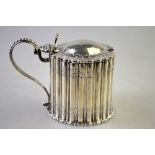 A Victorian silver mustard of reeded drum form with domed cover, beaded handle and blue glass liner,
