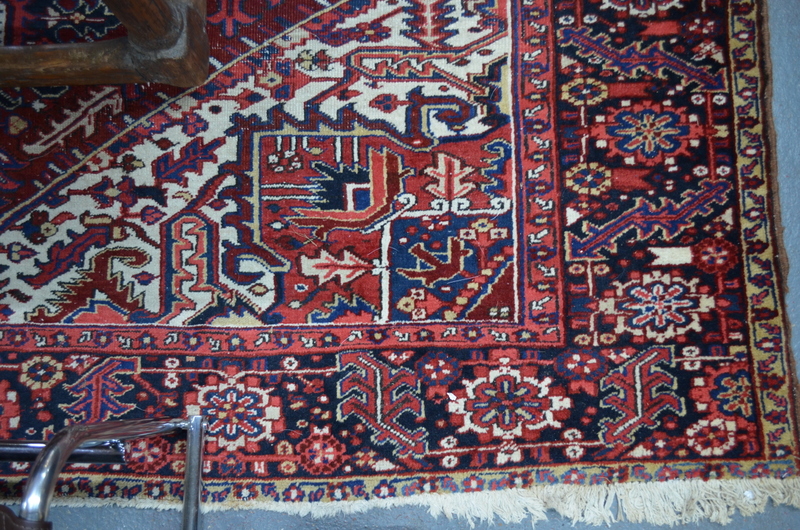 A Persian Heriz carpet, the large central blue medallion on red ground with stylised floral design,