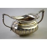 An Edwardian silver half-fluted sugar basin with moulded rim and twin handles,