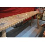 An antique oak stick leg pig stool/bench