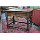 A 17th/18th century oak side table, the plank top over a frieze drawer,