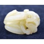 A small green jade of a recumbent, curled lion dog or other mythological animal, 4cm wide,