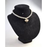 A Tiffany silver bead necklace having central heart shape drop, with silver gilt roses to centre,