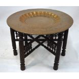 An Indian circular brass table decorated with a central scene of Mughal, or other Indian,