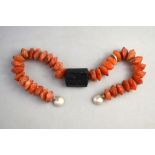A statement necklace featuring natural black mineral and roughly faceted cornelian beads