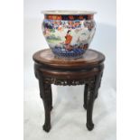 A Chinese wood stand with oval stone centre; together with a Japanese Imari planter,
