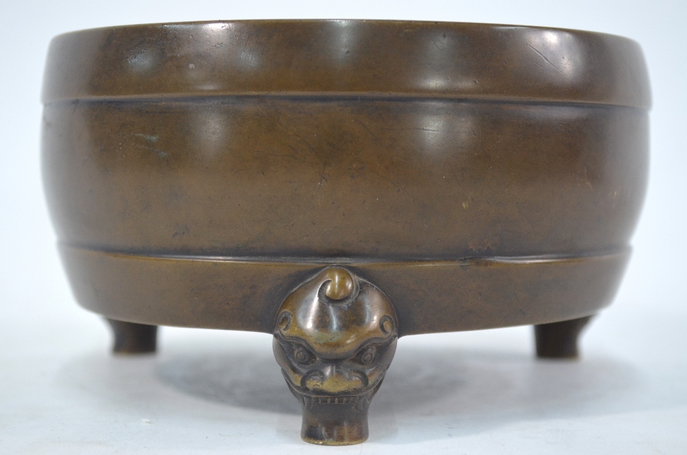 A bronze incense burner of circular form with three feet designed as mythological animal heads, 14.